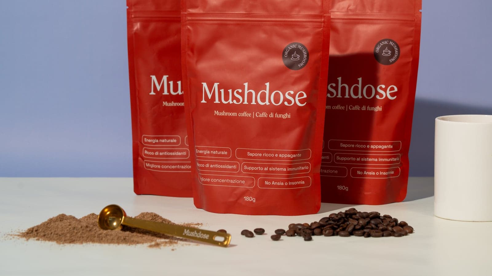 Le confezioni rosse Mushdose, il caffè e il misurino nello shooting del brand